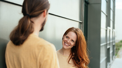 Wall Mural - Happy young woman chatting to a man