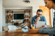 © bnenin - Couple looking through mail and using laptop at home.