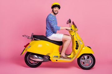 Wall Mural - Profile side view of his he nice attractive handsome cheerful cheery glad funky guy riding moped exploring world isolated over pink pastel color background