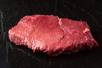 Steak raw. Barbecue Rib Eye Steak or rump steak on black stone