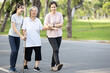 © Satjawat - Happy asian old senior woman with her family having fun,strolling in outdoor city park,relax and enjoy,elderly grandmother with her family walking together along the promenade,healthy life,health care