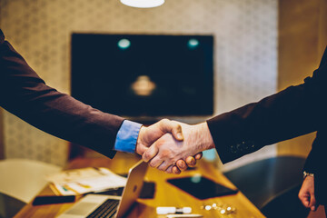 Cropped image of male's hands shaking in sign of making profitable deal for common business project,man agree in strategy of cooperation making contract for partnership in office during meeting