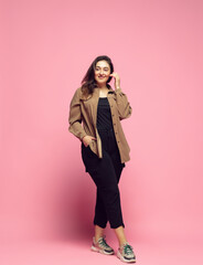 Wall Mural - Fashionable, stylish. Young woman in casual wear on pink background. Bodypositive character, feminism, loving herself, beauty concept. Plus size businesswoman, beautiful girl. Inclusion, diversity.