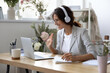 © fizkes - Smiling young Caucasian woman in headphones take online educational course or training on laptop from home, happy female in wireless headset wave to camera, talk on webcam video call on computer