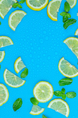  Frame from lemon slices and mint leaves on blue pastel table top view. Ingredients for summer drink and lemonade. Flat lay style
