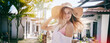 Beautiful happy blonde girl in a straw hat smiles joyfully, summer travel in the tropics. Movement and flying hair