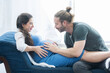 © supAVADEE BUTRADEE - The husband sat on the sofa, listened to his pregnant wife, and was happily talking with the new family in home.Pregnancy and people concept.