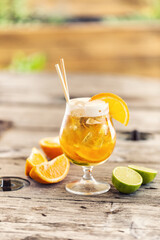 Wall Mural - Beer lemonade in a glass with freshly cut orange, ice and paper straws