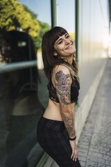 Poster - Young attractive Caucasian female with tattoos standing in the park making a cute face