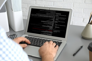 Professional programmer working with laptop in office, closeup
