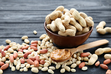 Poster - Peanut butter in spoon and nuts on black wooden table