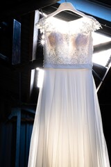 Canvas Print - Vertical shot of a beautiful wedding dress hanging around a vintage door