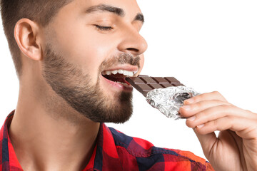 Wall Mural - Handsome young man with tasty chocolate on white background