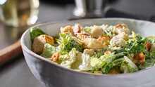 Fresh Caesar Salad With Croutons And Parmasan Cheese In Bowl