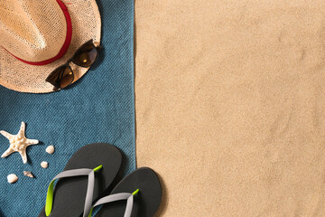 Wall Mural - Summer vacation composition. Flip flops, hat and sunglasses on sand background. Travel vacation concept. Summer background. Border composition made of towel