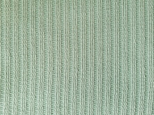 Knitted Textile Texture With A Vertical Pale Green Hue. Knitted Texture Pattern. Texture Of Knitted Cotton Thread For Wallpaper And An Abstract Background.