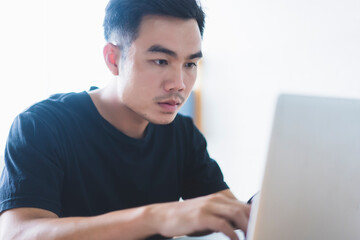 Work from home Asian businessman using laptop computer typing information work planning strategy business finance, in quarantine lockdown coronavirus covid-19 pandemic, working house modern office