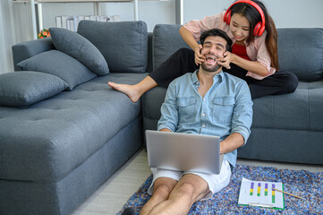 Happy and relax  lifestyle of young couple lover wearing casual dress together working on sofa with  laptop notebook computer in living room at home.