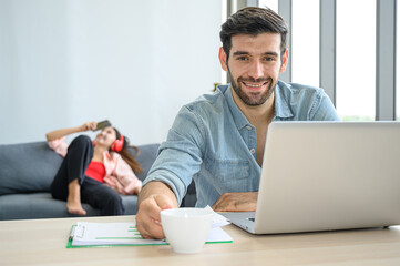 Happy and relax  lifestyle of young couple lover wearing casual dress together working on laptop notebook computer in living room at home.