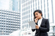 © Atstock Productions - Portrait of smiling young confident Hispanic businesswoman looking at tablet in urban city background