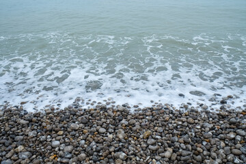 Wall Mural - French coastline of Normandy in France with pebbles beaches, part of the typical landscape 