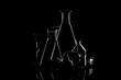 © Roman Kornev - Low-key Studio Shot of a White silhouette of a chemical laboratory utensils light glasses isolated on a black Background. Smooth lines and shapes. .