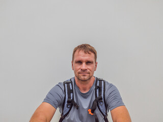 A beautiful young caucasian man in a gray shirt with a backpack. Travel concept with copy space