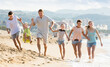 © JackF - Family with four children runnin on beach on weekend
