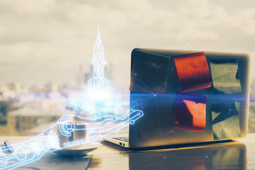 Desktop computer background in office and start up theme hologram drawing. Double exposure. Startup concept.