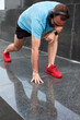 © astrosystem - Modern sporty man making pause and stretching after jogging / exercise in urban environment.