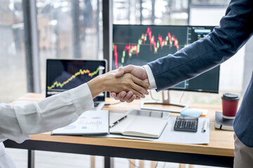 Wall Mural - Business handshake after discussion and analyzing graph stock market trading good deal of Trading to sign agreement and become a business partner, contract for both company