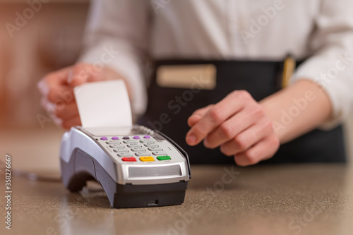 The waiter accepts payment through the terminal, non-cash payment. Restaurant business