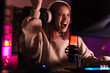 © Drobot Dean - Image of girl making winner gesture and playing video game on computer
