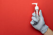 Gel hands on medical red background. Washing hands with antibacterial sanitizer gel in lab gloves. Clear sanitizer in pump bottle. Corona Virus pandemic protection by washing hands frequently