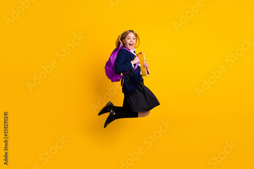 Full length body size view of her she small little cheerful genius diligent schoolchild jumping enjoying back to lesson classes isolated bright vivid shine vibrant yellow color background