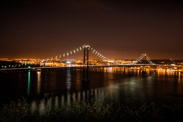 Wall Mural - night photo of a bridge with a reflection in the river.