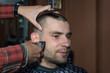 © Алексей Доненко - haircut of a young guy with a shield in a barbershop using a typewriter with a nozzle. Barbershop