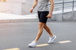 © Dima - Fitness man athlete runner walking on the road. Person running working out living an active lifestyle training cardio in summer in sportswear and shoes. Lower body banner crop. Close up.