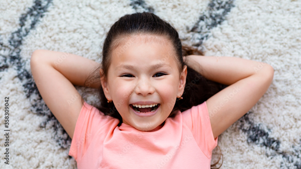 Little Girl Lying On Floor Smiling To Camera Indoor, Top-View Stock ...