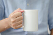 © photobuay - Mug mockup. businessman's hands holding mug with blank space for your text or promotional content.