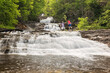 © romylee - a couple of hikers climbing a waterfall