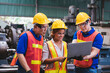 Group of creative asian technician engineer and engineer woman dark skin wearing uniform and safety helmet under inspection and checking production process on factory station by laptop computer.