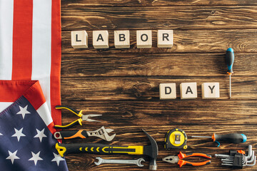 Poster - top view of metallic tools and american flag near cubes with labor day lettering on wooden surface