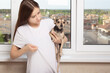 © yta - Young girl at home shows wool on clothes, holds a small dog in her arms