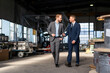 © Westend61 - Two businessmen walking and talking in a factory