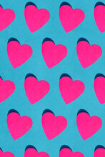 Seamless Pattern Of Pink Paper Hearts Against Blue Background