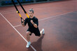 yound sporty athlete or bodybuilder has fitness workout with trx outdoor