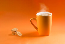 Orange Cup With Tea And Heart-shaped Cookies On Orange Gradient Background.