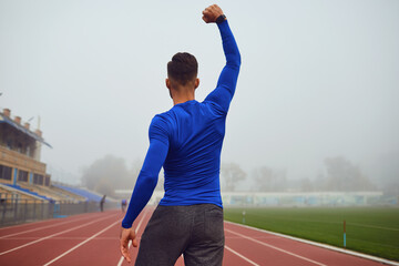 Wall Mural - The guy the athlete raised his hands up at the stadium in the fog.