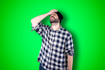 Wall Mural - Portrait of a puzzled bearded man holding hands on his head isolated over chroma background